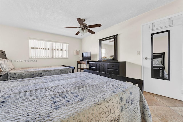 bedroom featuring ceiling fan, a textured ceiling, and light tile patterned flooring