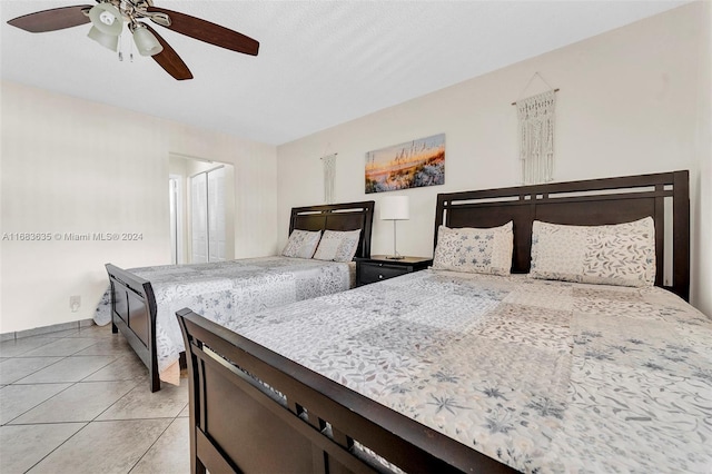 tiled bedroom featuring ceiling fan