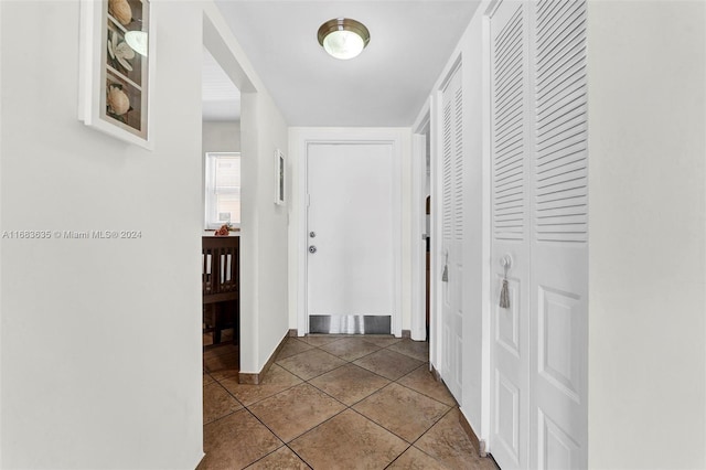 hall with tile patterned floors