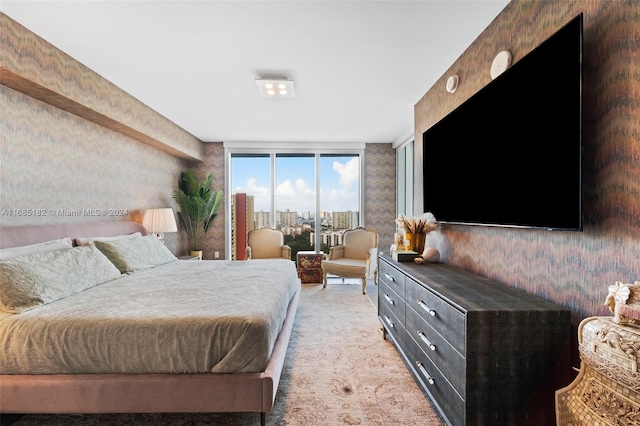 bedroom featuring expansive windows, carpet floors, and access to exterior