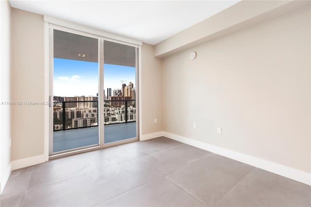 spare room featuring floor to ceiling windows and concrete flooring