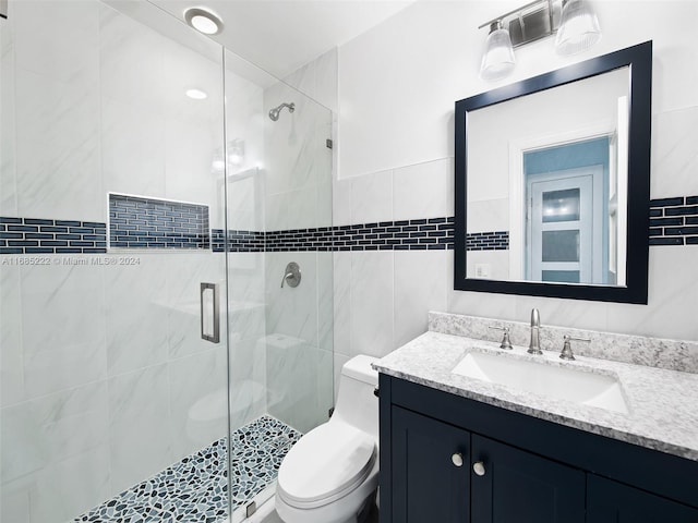 bathroom with vanity, a shower with shower door, and toilet