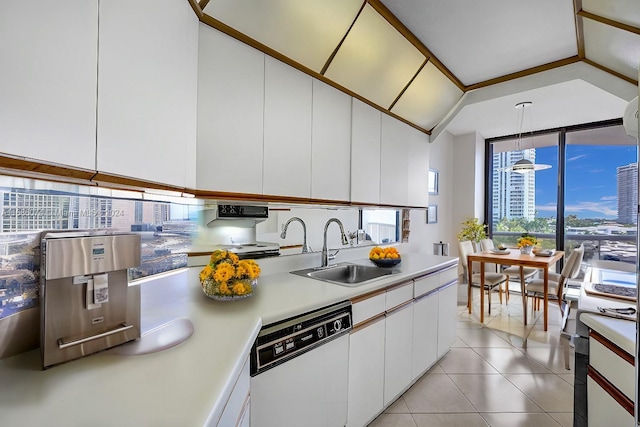 kitchen featuring pendant lighting, white appliances, white cabinets, sink, and vaulted ceiling