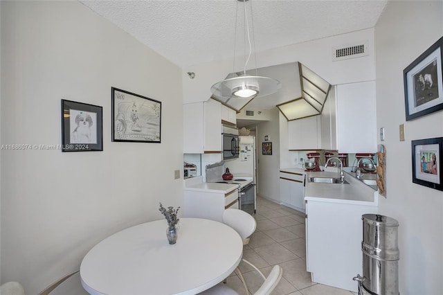 kitchen featuring hanging light fixtures, white cabinets, white range with electric stovetop, a textured ceiling, and light tile patterned floors