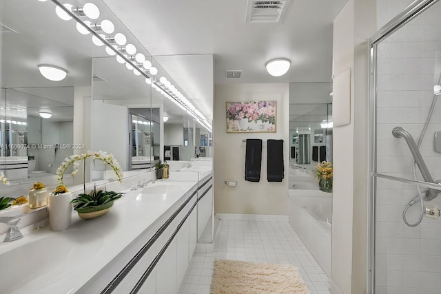 bathroom with tile patterned floors, vanity, and separate shower and tub