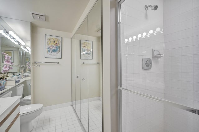 bathroom featuring tile patterned flooring, vanity, an enclosed shower, and toilet