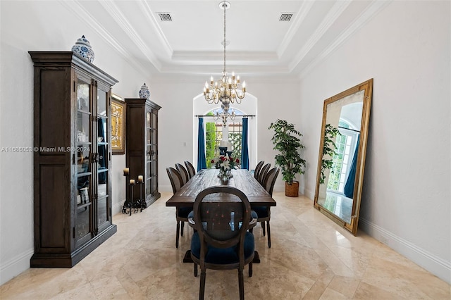 dining room featuring a tray ceiling, ornamental molding, and a notable chandelier