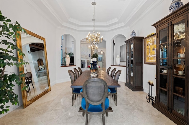 dining area featuring a tray ceiling, crown molding, and a chandelier