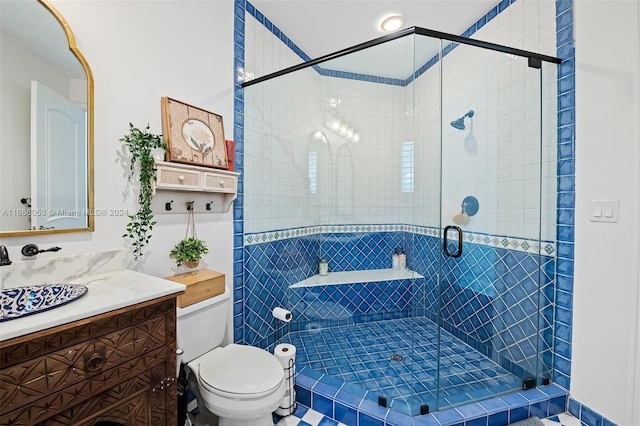 bathroom featuring vanity, toilet, and an enclosed shower