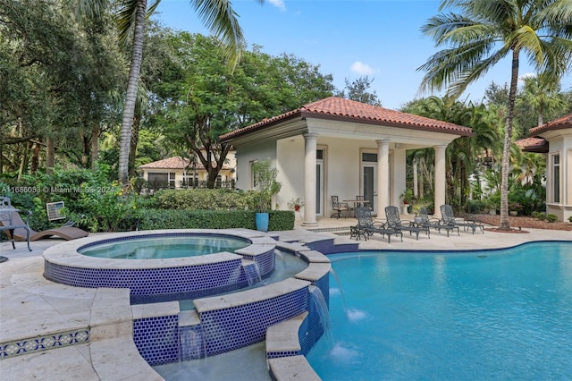 view of swimming pool with pool water feature, an in ground hot tub, and a patio