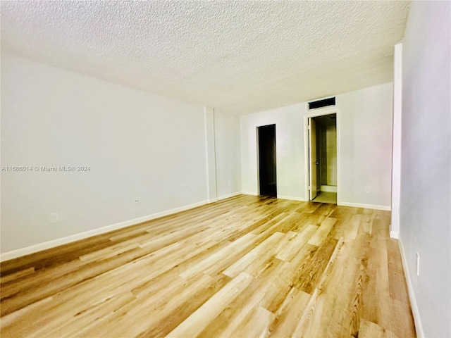 empty room featuring hardwood / wood-style floors and a textured ceiling