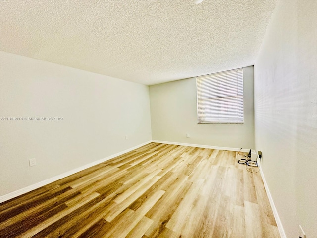 empty room featuring a textured ceiling and hardwood / wood-style flooring