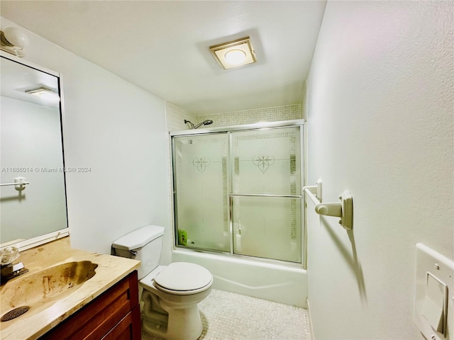 full bathroom featuring vanity, combined bath / shower with glass door, and toilet