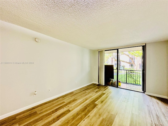 spare room with light hardwood / wood-style flooring and a textured ceiling