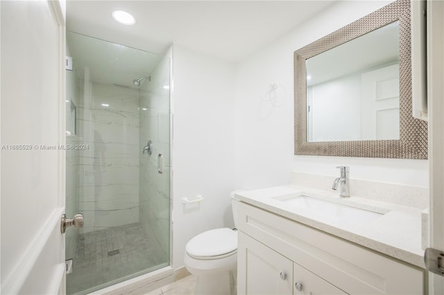 bathroom with vanity, toilet, and a shower with shower door