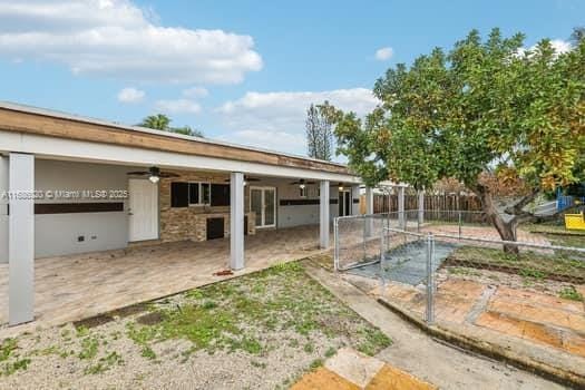 back of property featuring ceiling fan and a patio area