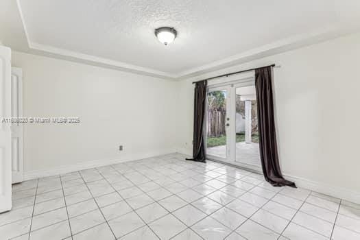 spare room featuring a textured ceiling, a tray ceiling, and french doors