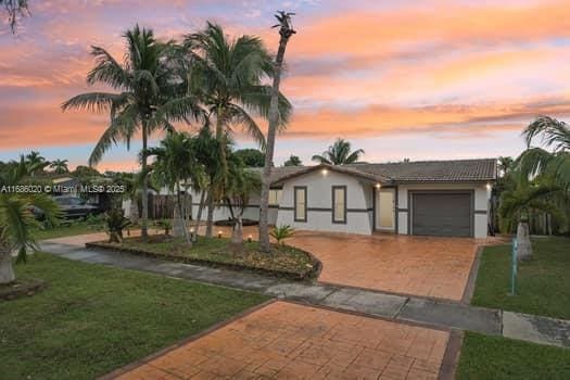 view of front of home featuring a yard and a garage