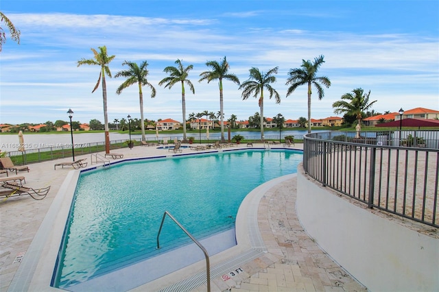 view of pool with a patio and a water view