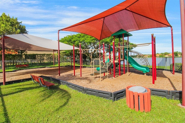 view of jungle gym with a lawn and a water view