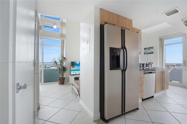 kitchen with stainless steel appliances, hanging light fixtures, sink, and light tile patterned floors