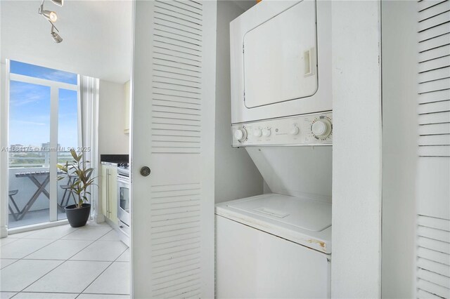 washroom featuring stacked washer and dryer and light tile patterned floors