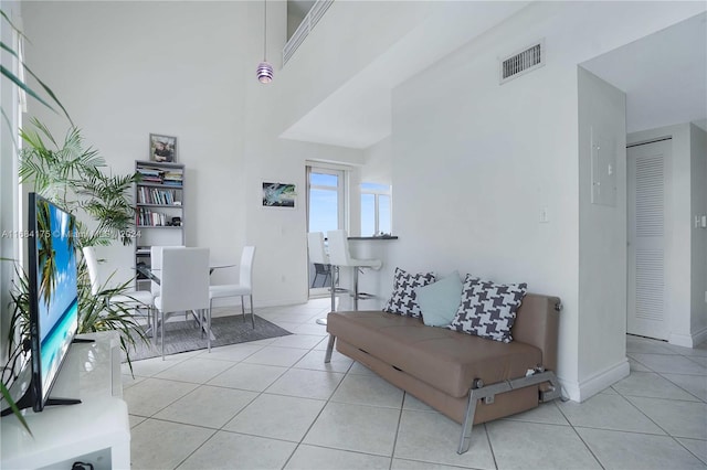 living room featuring light tile patterned flooring and a high ceiling