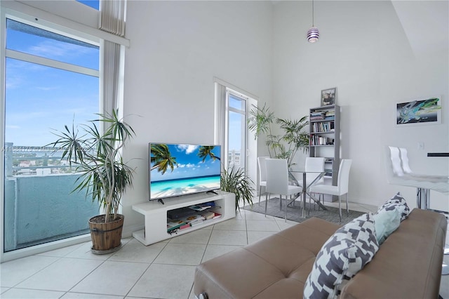 tiled living room featuring a towering ceiling and plenty of natural light