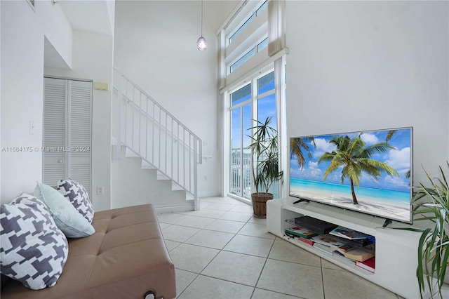 tiled living room featuring a high ceiling