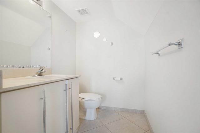 bathroom with lofted ceiling, vanity, toilet, and tile patterned floors