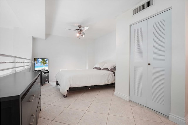 tiled bedroom featuring ceiling fan and a closet