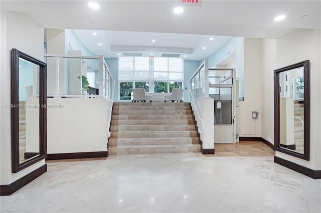 stairway with a tray ceiling