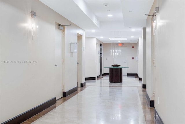 hall featuring a tray ceiling