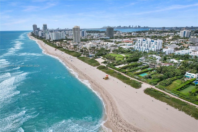 bird's eye view with a water view and a beach view