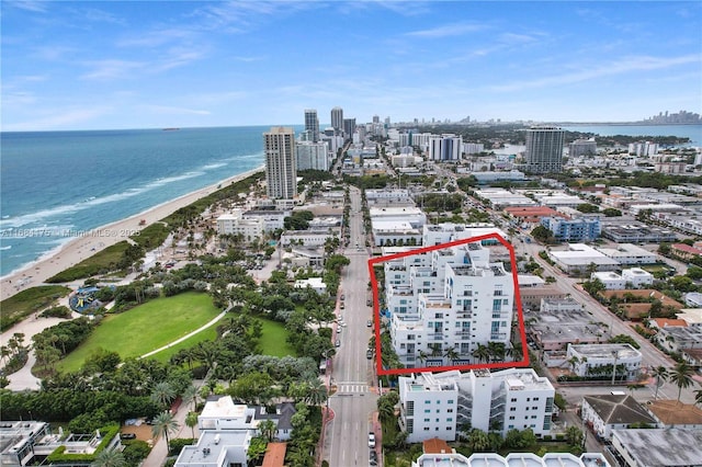 drone / aerial view featuring a beach view and a water view