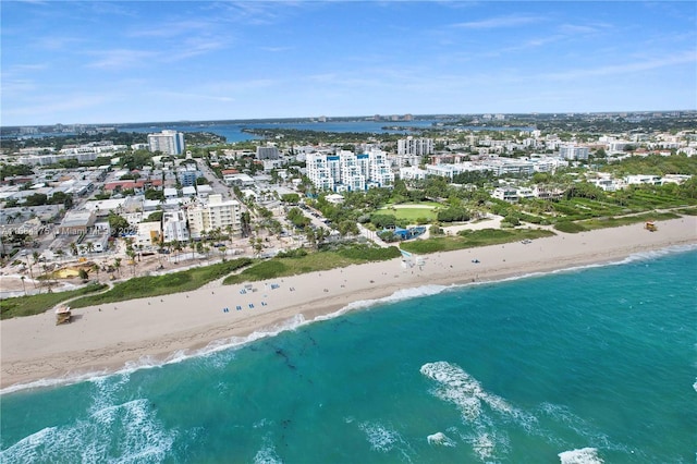 birds eye view of property with a water view and a beach view