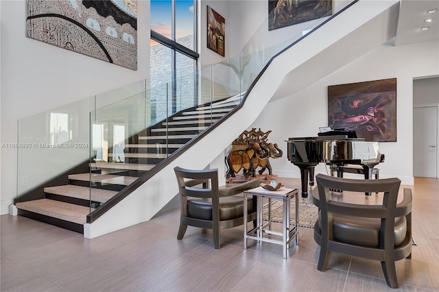 stairway with hardwood / wood-style floors and a high ceiling