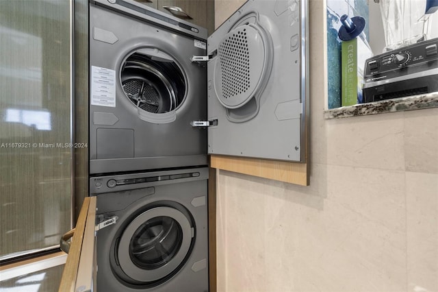 washroom with stacked washing maching and dryer