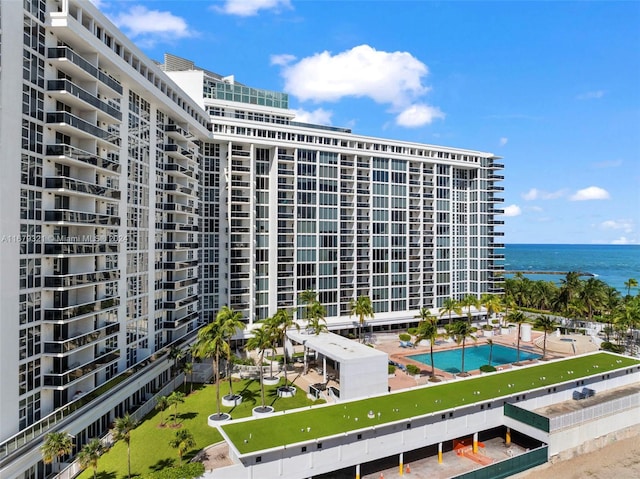 view of property with a community pool and a water view