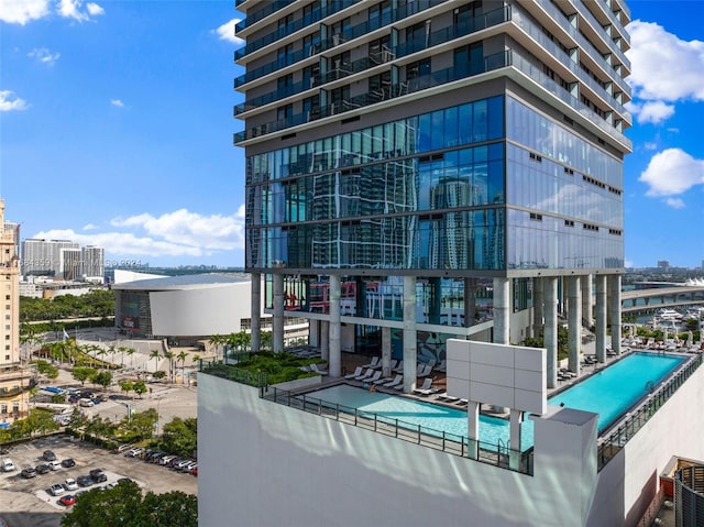 view of building exterior featuring cooling unit and a community pool