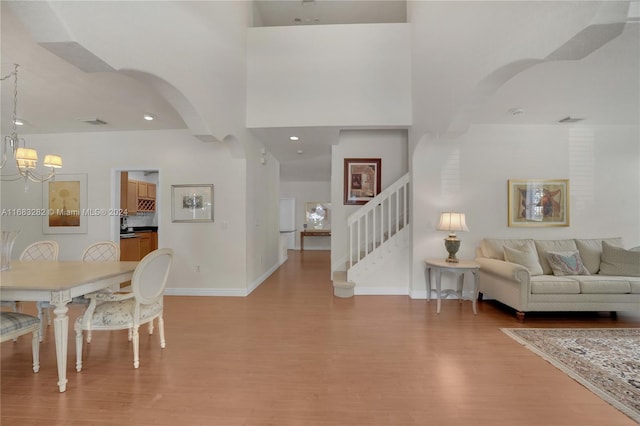 dining area featuring hardwood / wood-style flooring, a high ceiling, and a notable chandelier