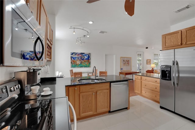 kitchen with kitchen peninsula, appliances with stainless steel finishes, sink, and light tile patterned floors