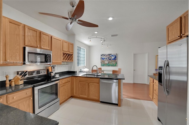 kitchen featuring sink, kitchen peninsula, appliances with stainless steel finishes, ceiling fan, and light tile patterned floors