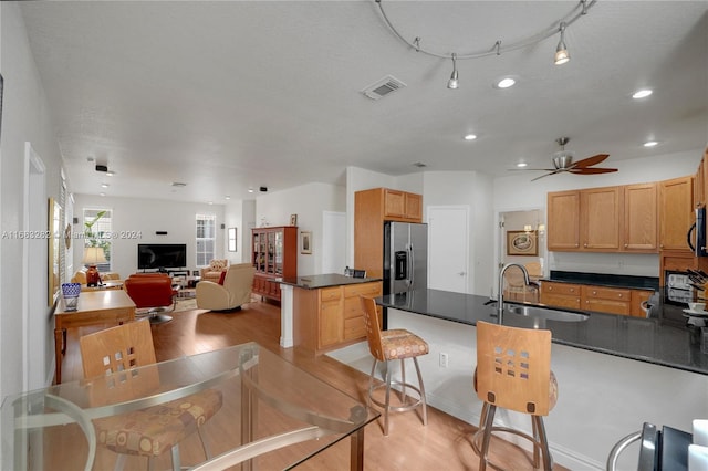 kitchen featuring sink, appliances with stainless steel finishes, ceiling fan, a textured ceiling, and light hardwood / wood-style flooring