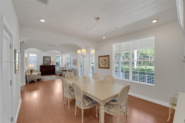 dining area featuring a wealth of natural light, a chandelier, and hardwood / wood-style flooring