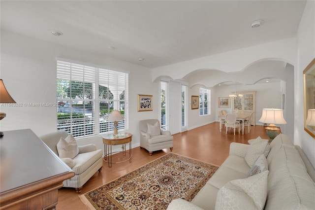 living room with hardwood / wood-style floors and an inviting chandelier