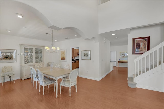 dining space with light wood-type flooring and a notable chandelier