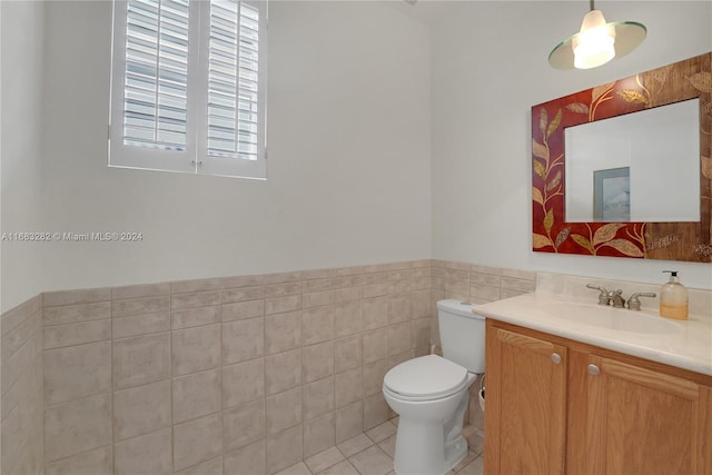 bathroom featuring toilet, tile walls, vanity, and tile patterned floors