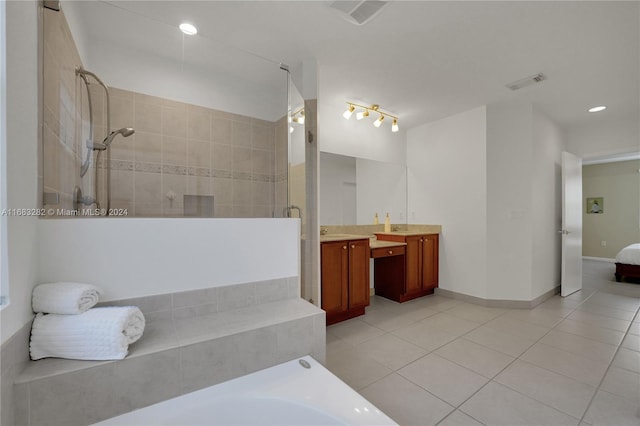 bathroom with tiled shower, vanity, and tile patterned floors