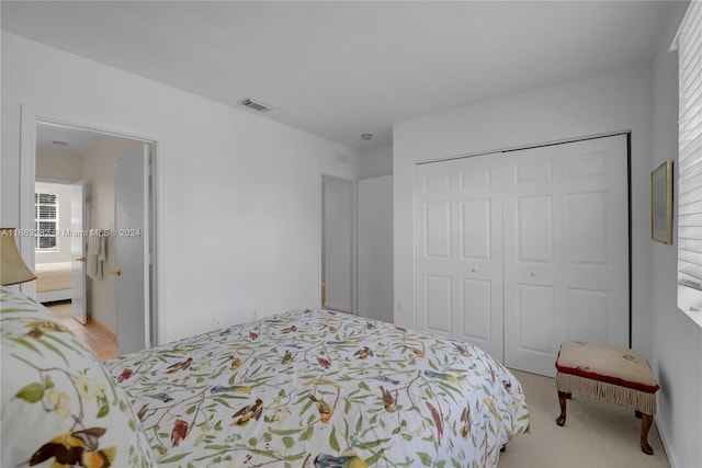 bedroom with light colored carpet and a closet